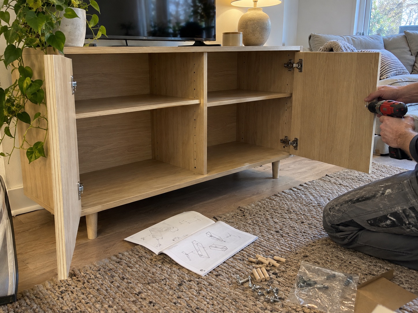 A light wood flat-pack cabinet being assembled